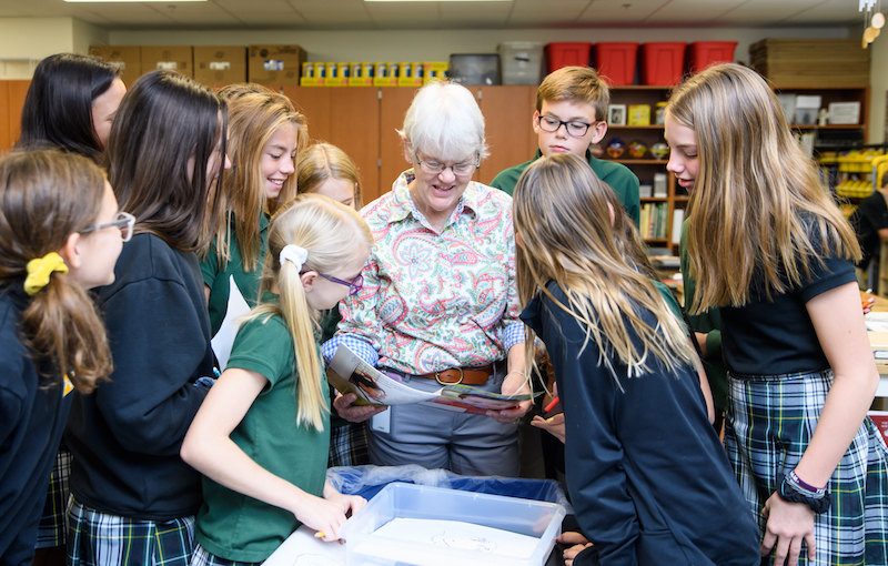 Lin Mayberry, Legacy Christian Academy middle school art teacher. surrounded by a group of students