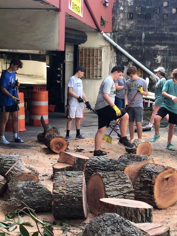 Legacy Christian Academy Middle School students chopping wood while in Houston